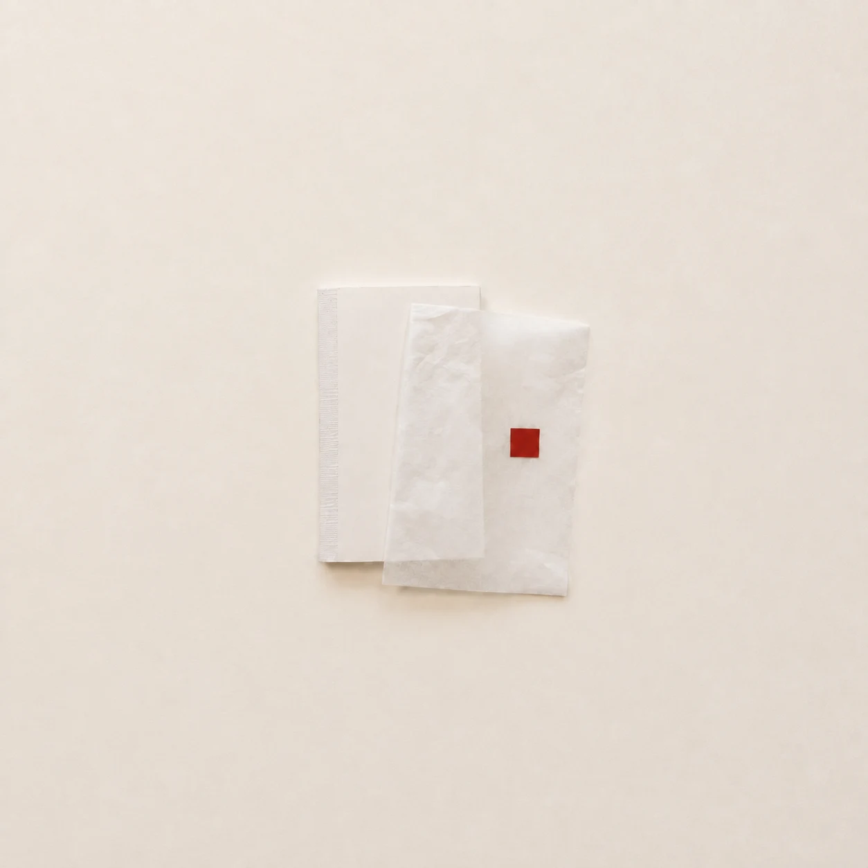Layered white papers with a small red square